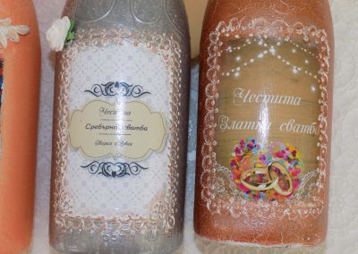 Декорирани бутилки с вино за подарък на младоженците.